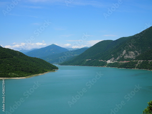 beautiful landscape overlooking a large blue lake in the mountains covered with forest