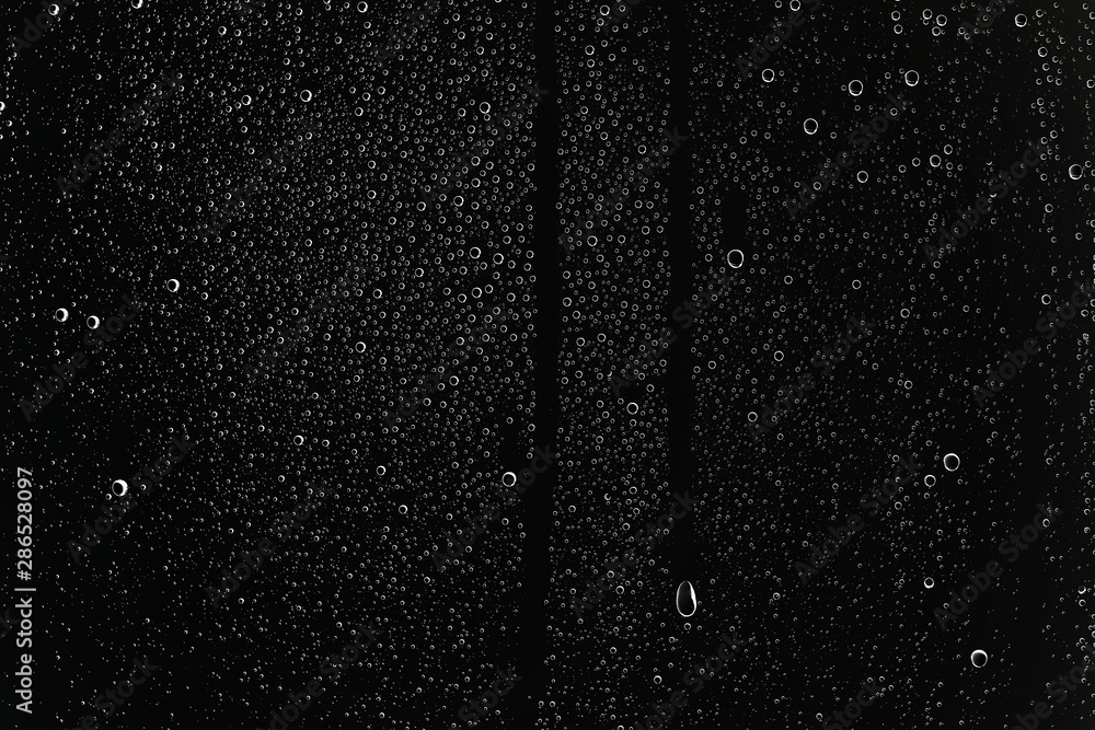 Obraz premium black wet background / raindrops for overlaying on window, concept of autumn weather, background of drops of water rain on glass transparent