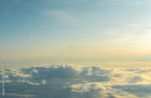 Above the clouds on a morning sunrise with blue sky above
