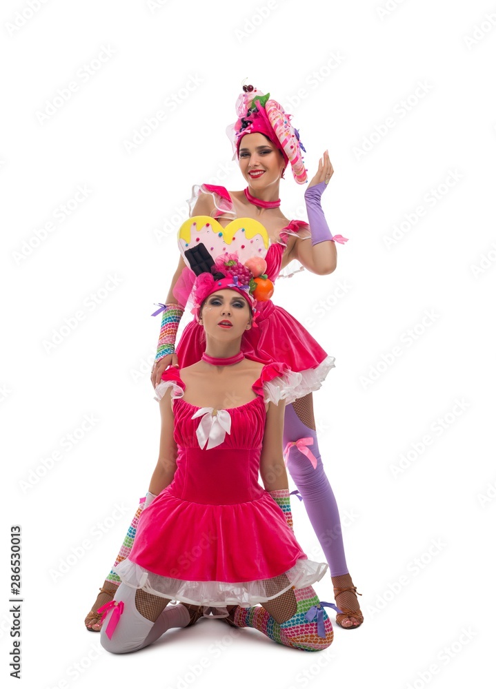 Playful dancers in original hats and dresses view