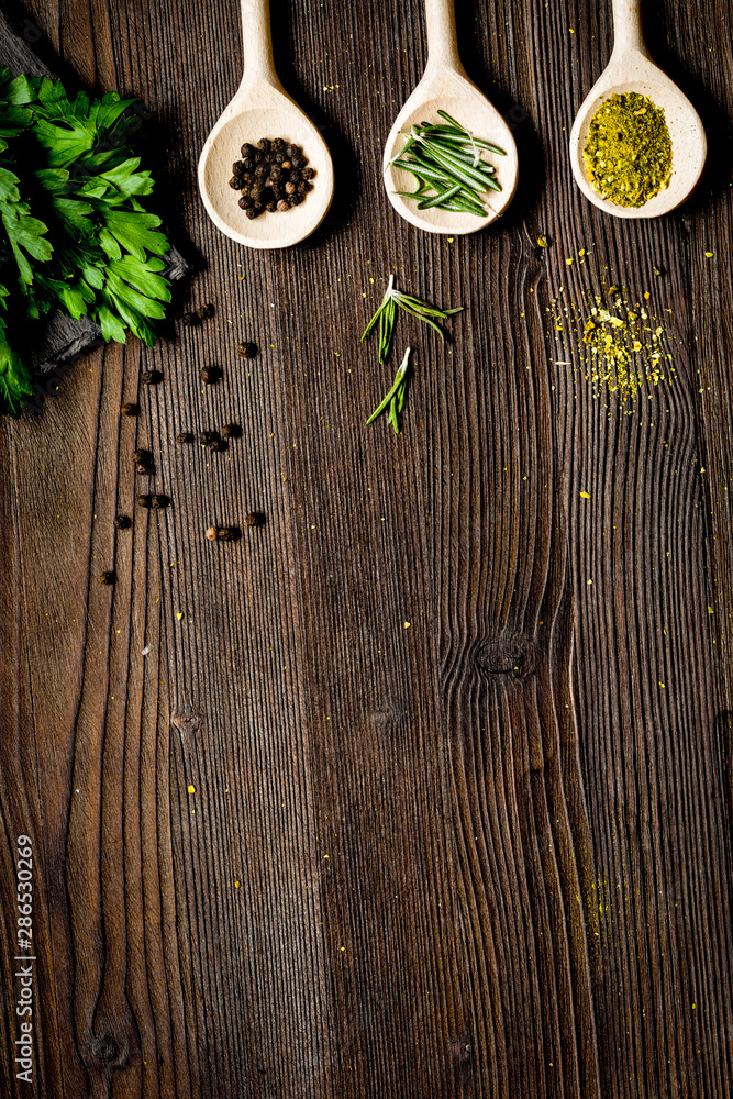 spices and fresh salad on dark wooden table top view