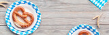 Oktoberfest, flat lay on rustic wooden table with pretzel and wheat ears, banner composition