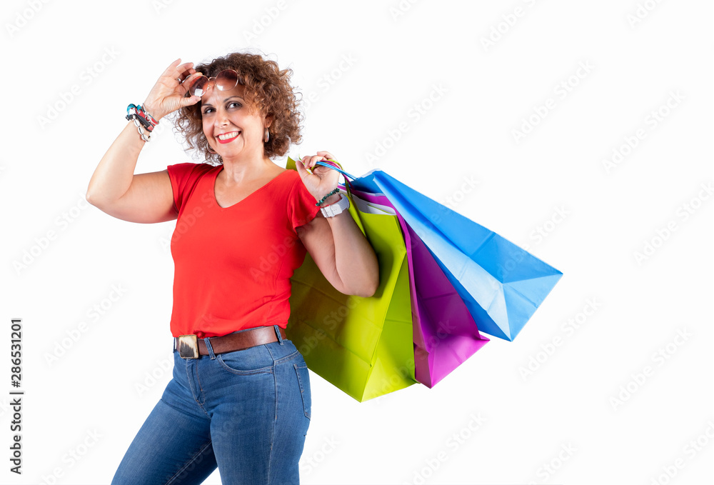Portrait of a smiling woman wearing glasses holding shopping bags and looking at the insulated camera on a white background. Portrait of a smiling woman wearing glasses holding shopping bags and looking at the insulated camera on a white background.