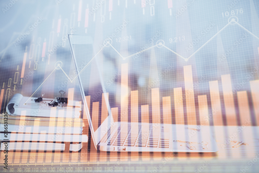 Stock market graph on background with desk and personal computer. Multi exposure. Concept of financial analysis.