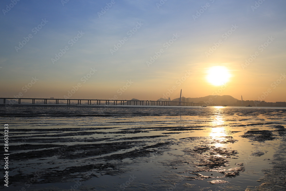 Fototapeta premium sunset of tidal beach and sunlit of chinese boat Ha Pak Nai at Yuen Long