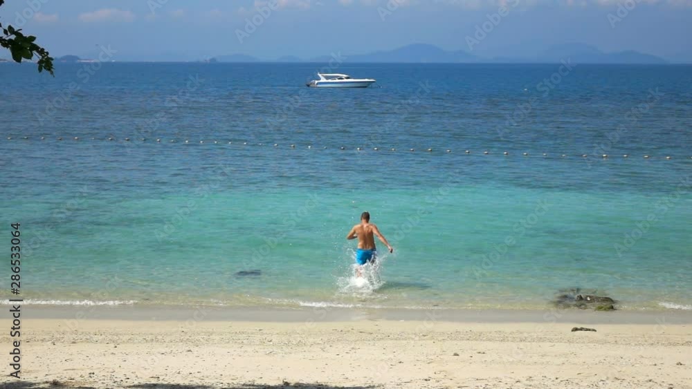 Young man running on beach into sea, super slow motion 240fps Young man running on beach into sea, super slow motion 240fps