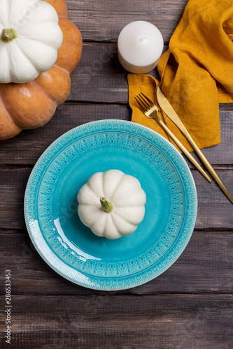 Empty serving plate with pumpkin  tableware and napkin on wood background