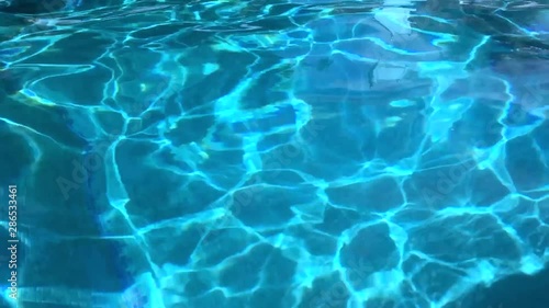 Water abstract background, Swimming pool rippled. Hotel swimming pool with sunny reflections
