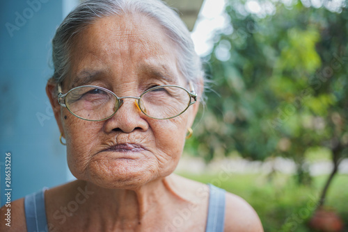Close-up, Asian senior elderly 81s-89 year woman wearing glasses is face smiling at home