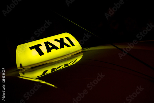 Photography yellow taxi sign on the roof of cab at night