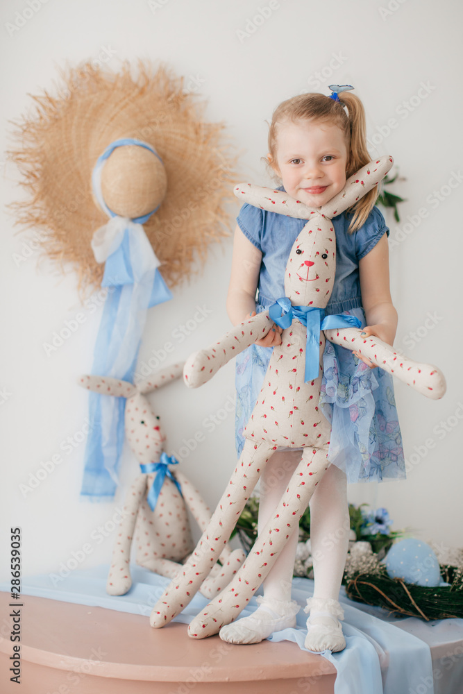 Fototapeta premium Cute little girl with a bunny rabbit at Easter.