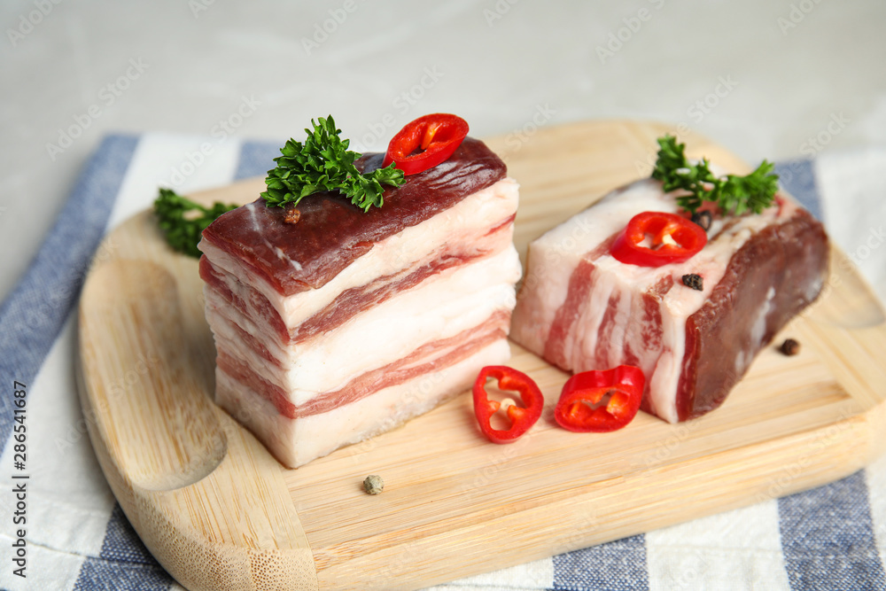 Board with bacon and pepper on grey background, closeup Board with bacon and pepper on grey background, closeup