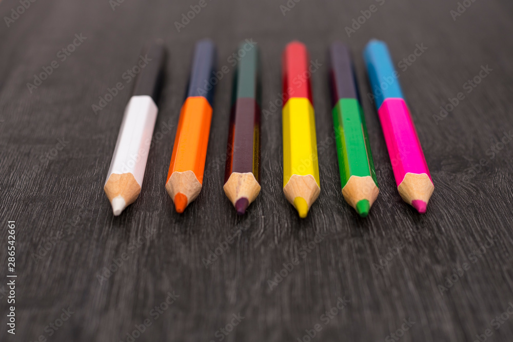 Colored pencils isolated on dark wooden background Colored pencils isolated on dark wooden background