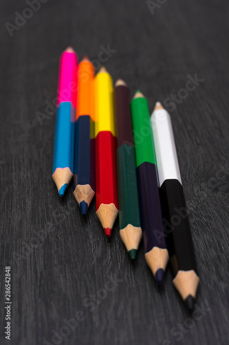 Colored pencils isolated on dark wooden background