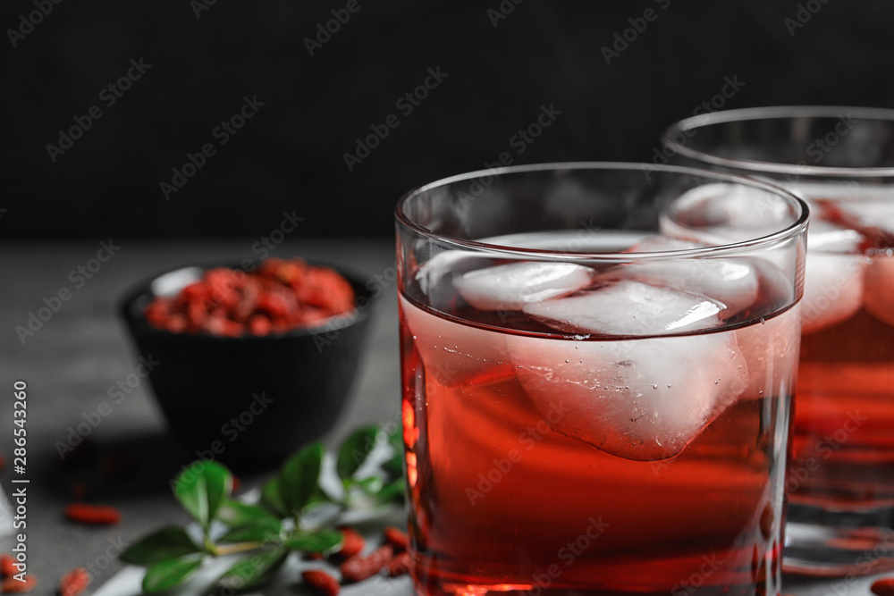 Healthy goji juice with ice in glasses on table, closeup Healthy goji juice with ice in glasses on table, closeup
