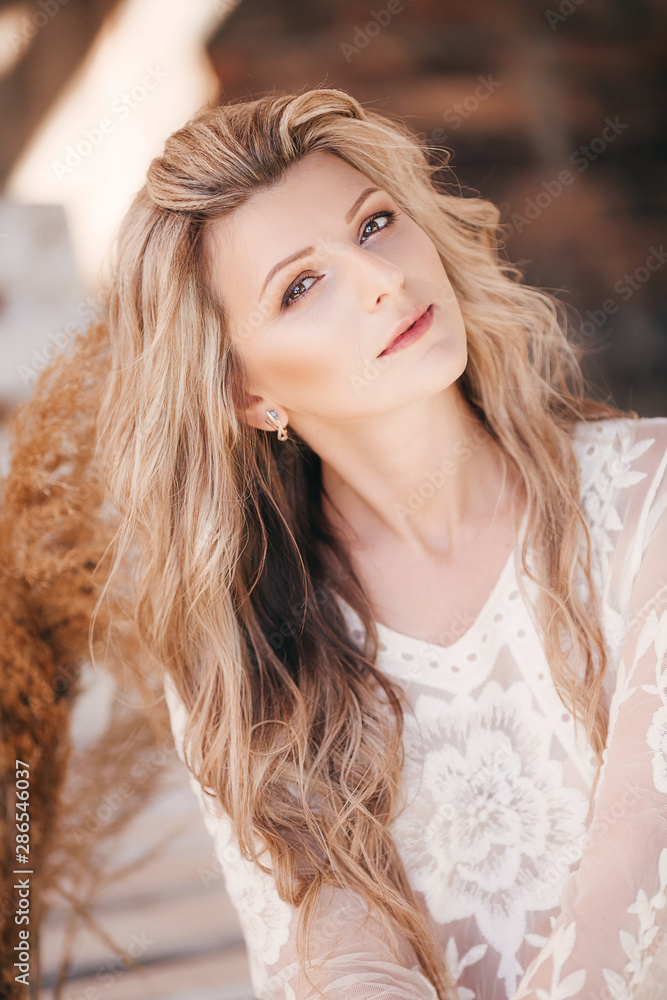Portrait of beautiful young blonde woman with makeup in white dress Portrait of beautiful young blonde woman with makeup in white dress