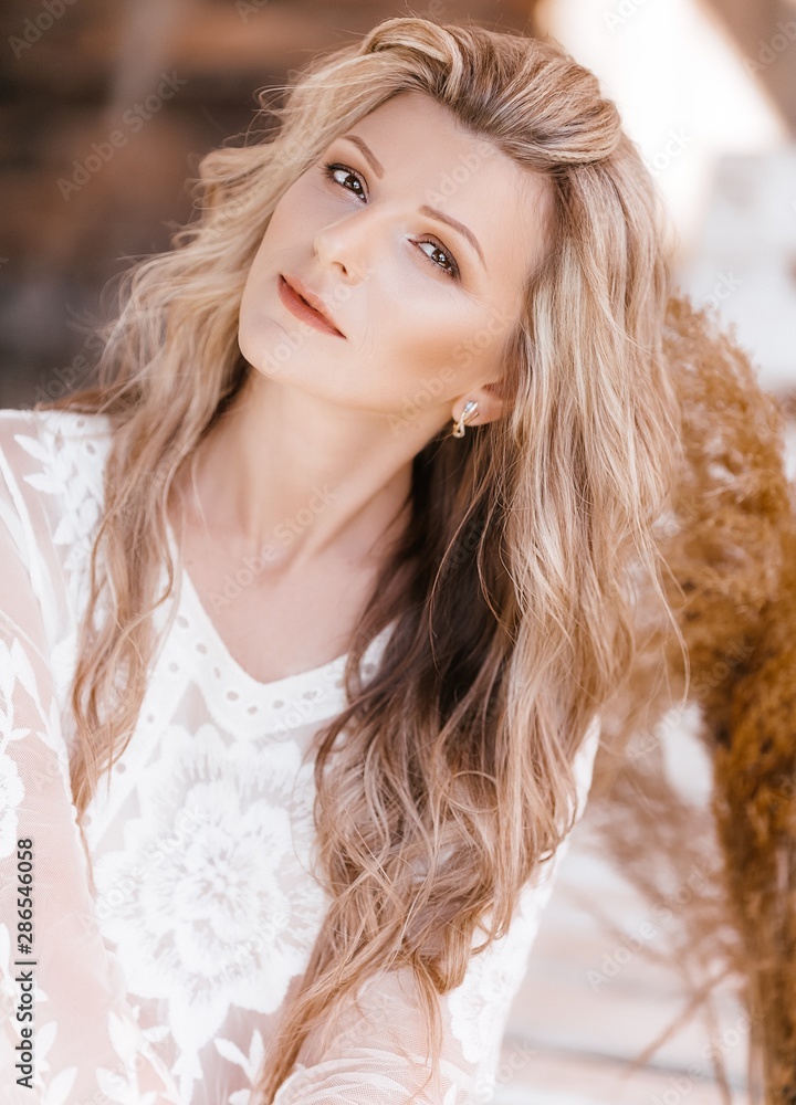 Portrait of beautiful young blonde woman with makeup in white dress Portrait of beautiful young blonde woman with makeup in white dress