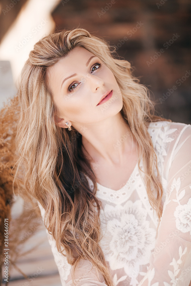 Portrait of beautiful young blonde woman with makeup in white dress Portrait of beautiful young blonde woman with makeup in white dress