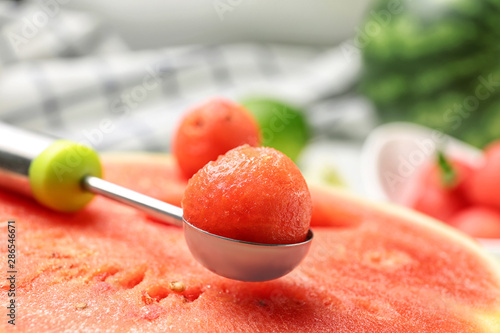 Scoop with delicious juicy watermelon on table, closeup photo