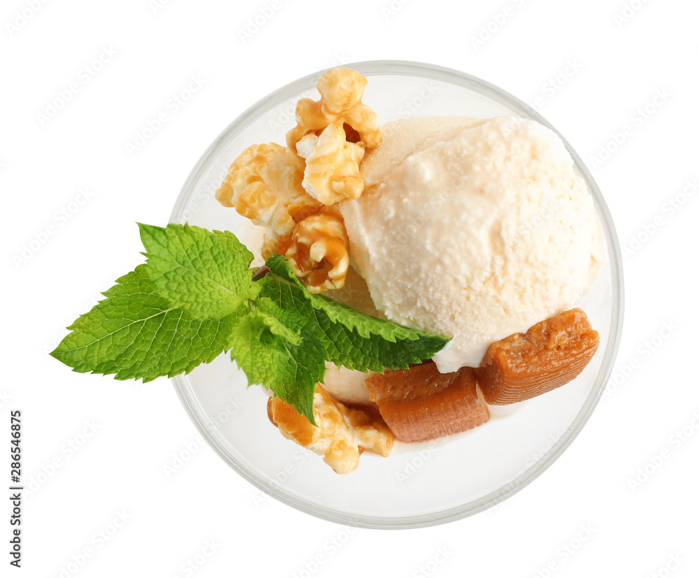 Glass bowl of ice cream with caramel candies, mint and popcorn on white background, top view Glass bowl of ice cream with caramel candies, mint and popcorn on white background, top view