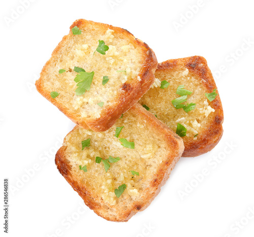 Slices of toasted bread with garlic and herb on white background, top view