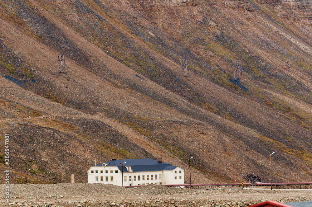 Old coal lorry above a new building, Longyearbyen, Svalbard, Norway Old coal lorry above a new building, Longyearbyen, Svalbard, Norway