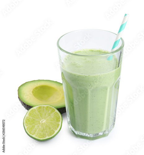 Glass of tasty smoothie with avocado and lime on white background