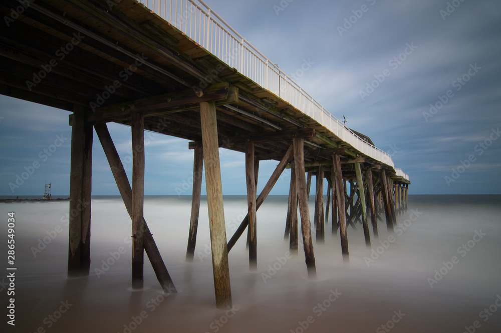 Old wooden fishing pier out to ocean Old wooden fishing pier out to ocean