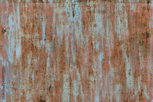 Spots of pink, blue and gray paint on the surface of an old metal sheet. Grunge texture.