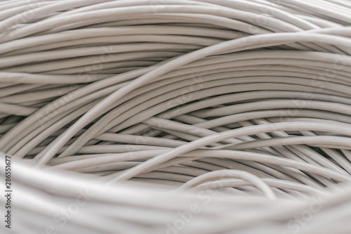 Bunch of gray Unshielded twisted pair cables is a close-up. Abstract technological background texture. The concept of wired Internet communications.