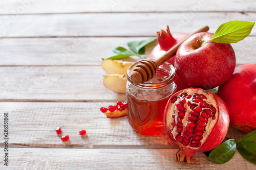 Rosh Hashana concept, jewish New Year holiday with traditional symbols: apples, pomegranate and honey photo