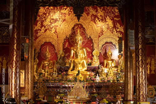 Interior of a Buddhist temple with many golden statues, Chiang Mai, Thailand