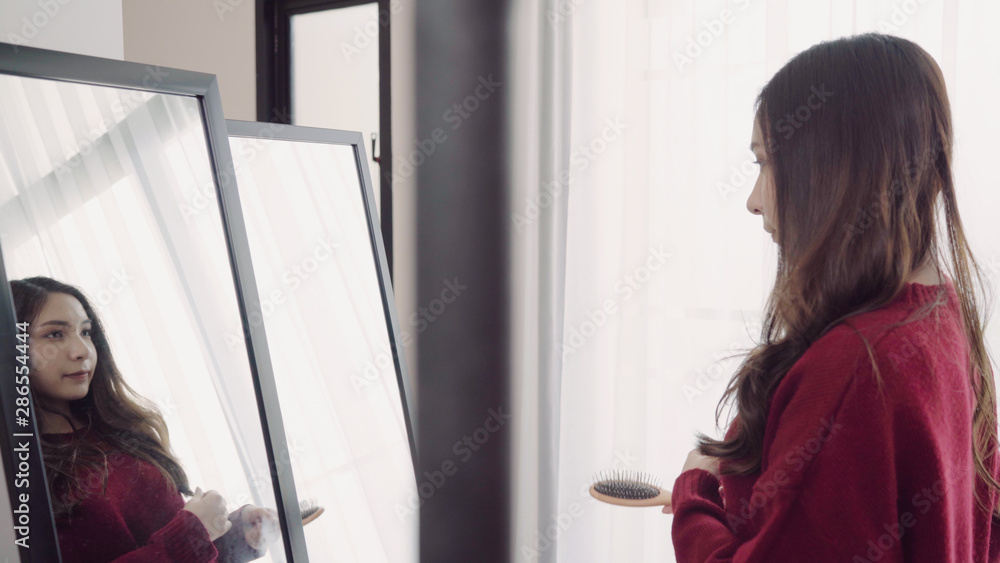 Portrait of beautiful attractive Asian woman combing her hair and choosing clothes in her dressing room at home. Lifestyle women using relax time at home concept. Portrait of beautiful attractive Asian woman combing her hair and choosing clothes in her dressing room at home. Lifestyle women using relax time at home concept.