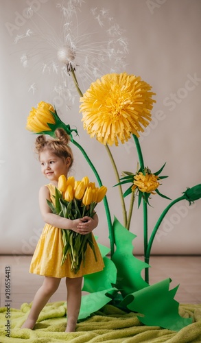 Portrait of beautiful little girl with yellow flowers