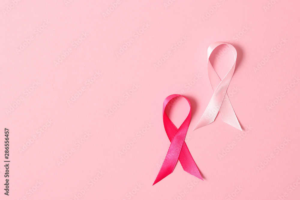 Pink ribbon on a colored background top view. Cancer disease. Pink ribbon on a colored background top view. Cancer disease.