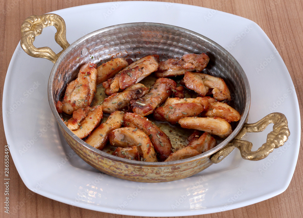 Serving fried chicken in copper dish and white plate from close angle on wooden table Serving fried chicken in copper dish and white plate from close angle on wooden table