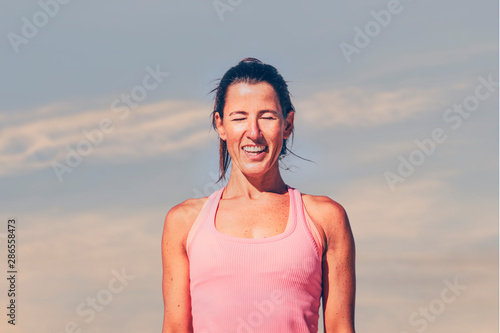 Young sporty woman laughing at sunrise or sunset.