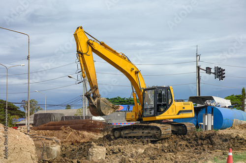Yellow earthmover backhoe on soil at construction site