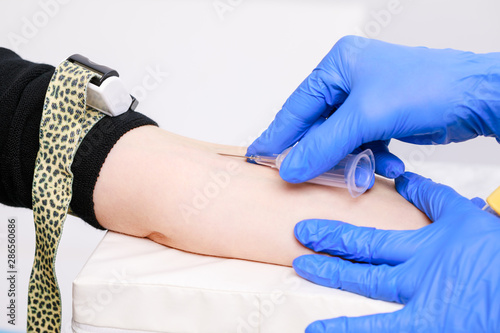Nurse takes a blood sample from arm vein performing a venipuncture