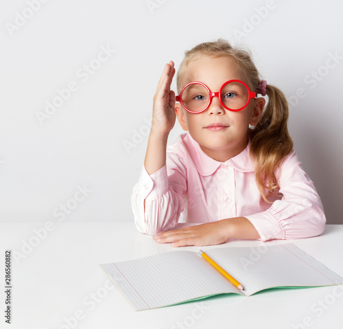 a schoolgirl with glasses at a table