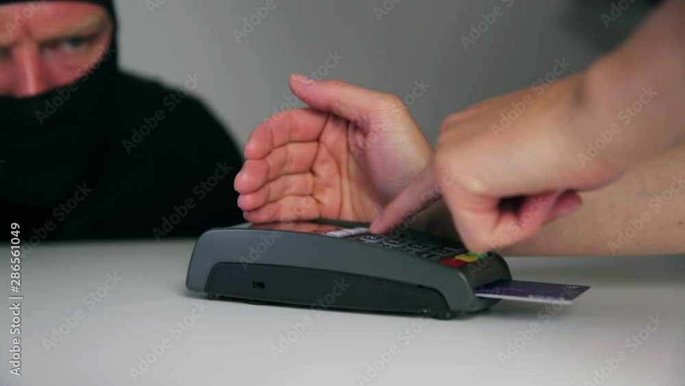Thief is stealing pin code and identity on payment (pos) terminal machine. Crime concept Thief is stealing pin code and identity on payment (pos) terminal machine. Crime concept