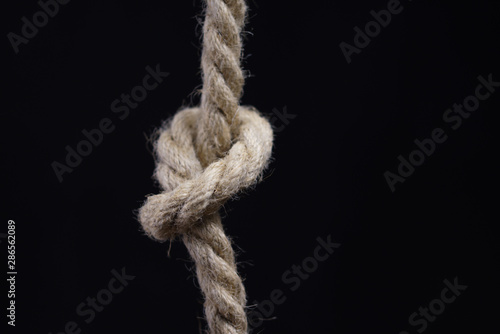 Rope with knot on black background © IBeart