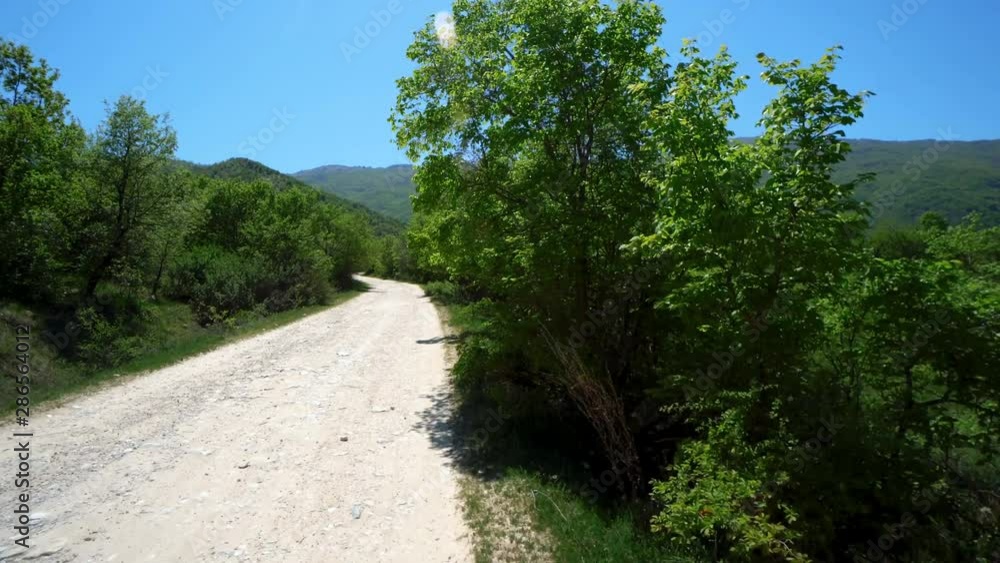 Off-road riding on a mountainous road among spring trees Off-road riding on a mountainous road among spring trees