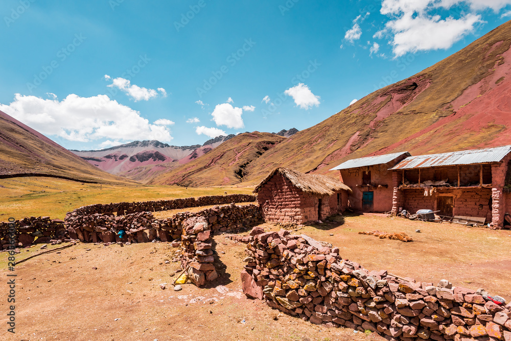 Trekking through the Red Valley, Vinicunca Rainbow Mountain, Cusco, Peru an amazing landscape scenery with colorful mountains and red hills with Alpaca and farmers of the Andean civilisation