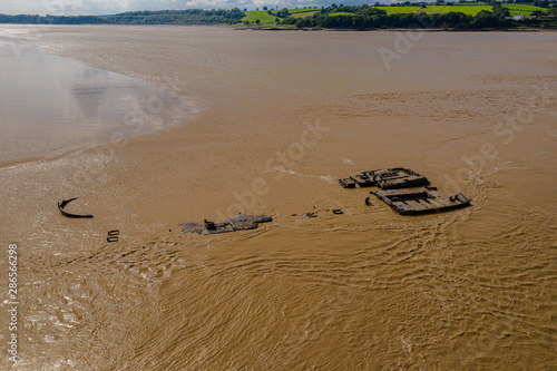 Aerial drone view of rusting hulls of abandoned ships in a brown, muddy river (River Severn) photo