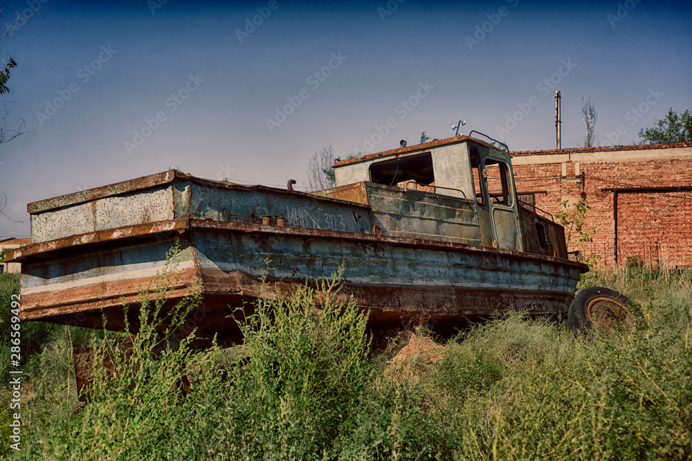 A broken boat stands on land. A broken boat stands on land.
