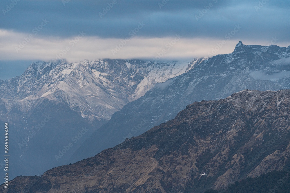 mountain peak cover by cloud at poon hill trekking route with airplane