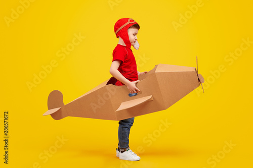 Little aviator in cardboard plane