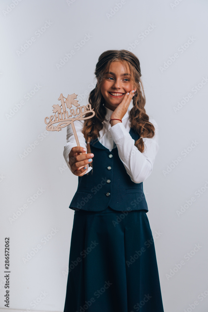 Schoolgirl posing with a bouquet of flowers. Girl in a school suit. Day of Knowledge. September 1. Schoolgirl posing with a bouquet of flowers. Girl in a school suit. Day of Knowledge. September 1.