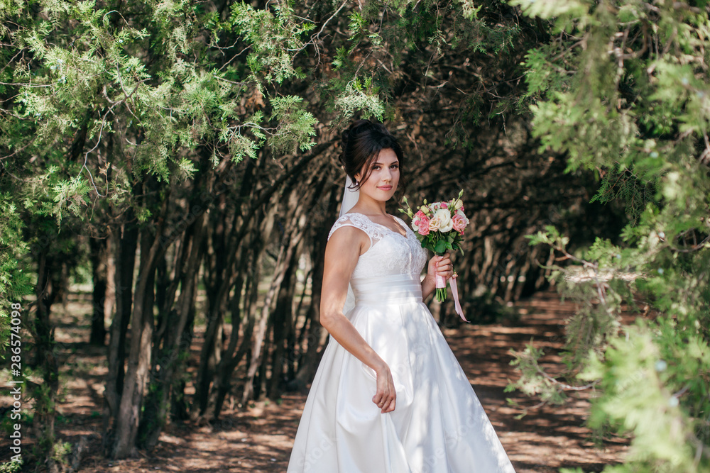 Beautiful bride with stylish make-up in white dress in spring garden Beautiful bride with stylish make-up in white dress in spring garden